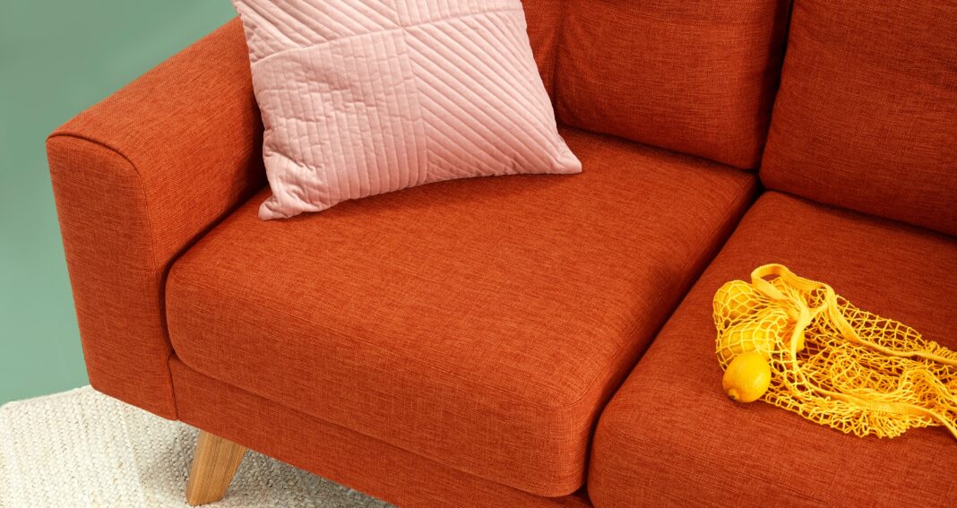 Bilden visar en soffa med prydnadskudde. Prydnadskuddar är snyggt till fåtöljer, soffor och sängar.