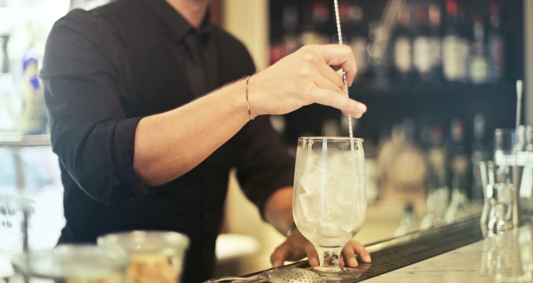 Bilden visar en bartender som använder is från olika typer av ismaskiner. Ismaskiner används för att producera exempelvis isbitar och iskross.