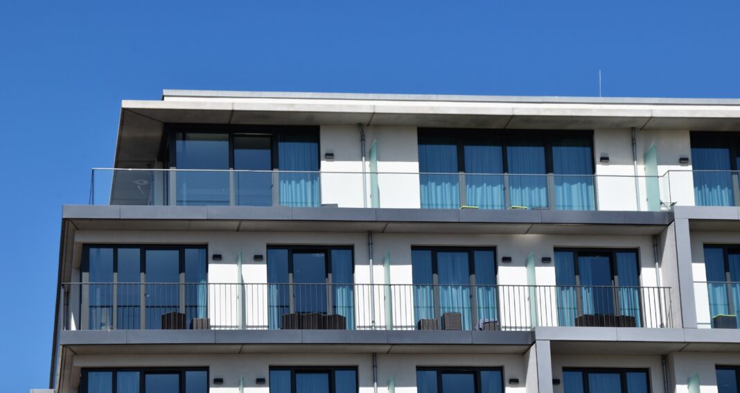 Bilden visar ett modernt hus. Solskyddsfilm till fönster är ett effektivt sätt att stänga ute varma solstrålar och minska insynen på inglasade altaner, balkonger och fönster.